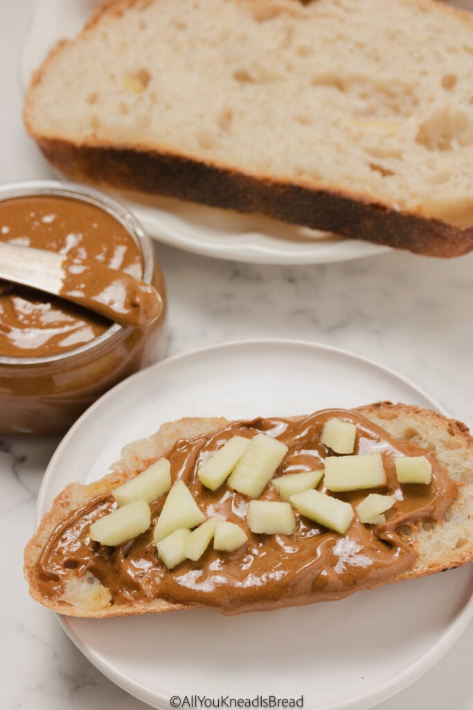 a slice of apple sourdough bread with homemade almond butter and apple chunks